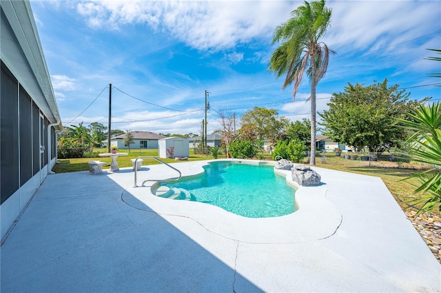 pool featuring a patio area, a storage unit, a lawn, and an outdoor structure