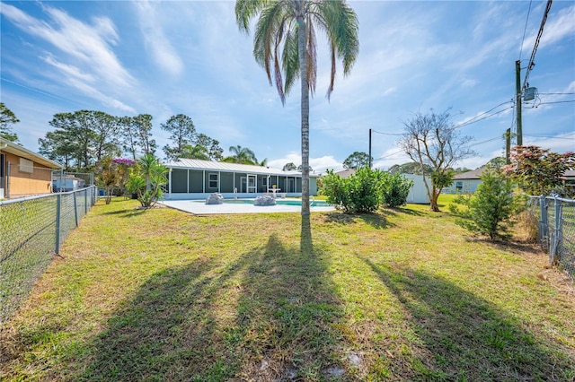 view of yard featuring a fenced in pool, a sunroom, and a fenced backyard