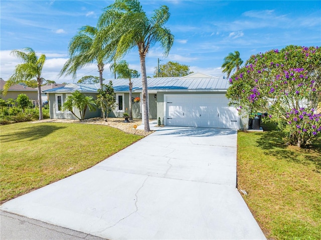 single story home with metal roof, concrete driveway, a front lawn, and an attached garage