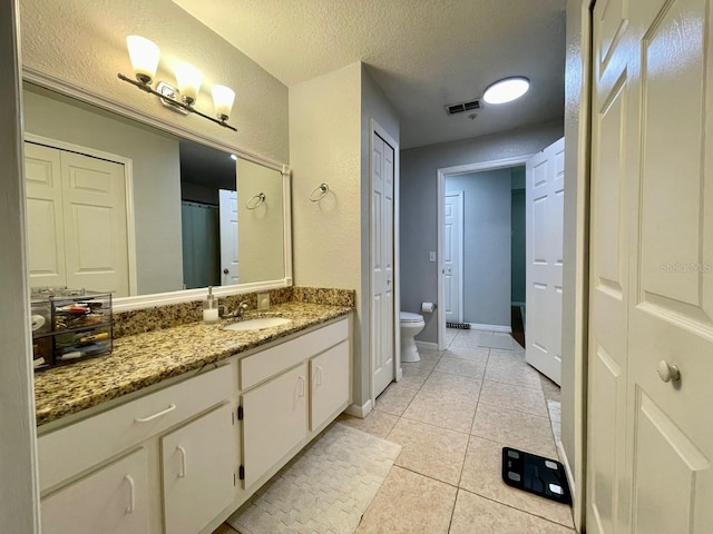 full bathroom featuring visible vents, toilet, tile patterned floors, a textured ceiling, and vanity