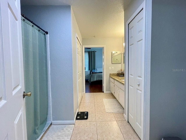 bathroom featuring a textured ceiling, connected bathroom, tile patterned floors, vanity, and a shower with curtain