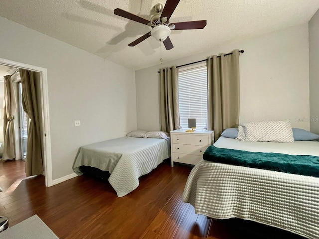 bedroom featuring a textured ceiling, multiple windows, wood finished floors, and a ceiling fan