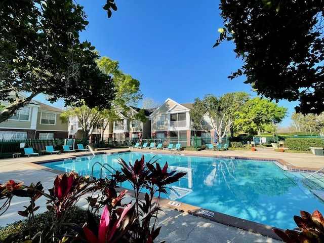 pool with a patio area and fence