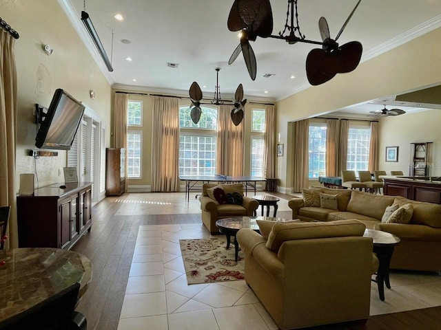 living area featuring a wealth of natural light, visible vents, and crown molding