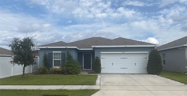 single story home featuring stucco siding, concrete driveway, fence, a garage, and a front lawn