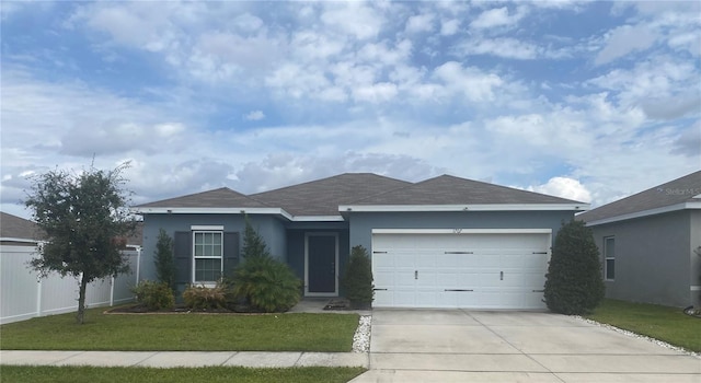 single story home with a garage, concrete driveway, fence, a front lawn, and stucco siding