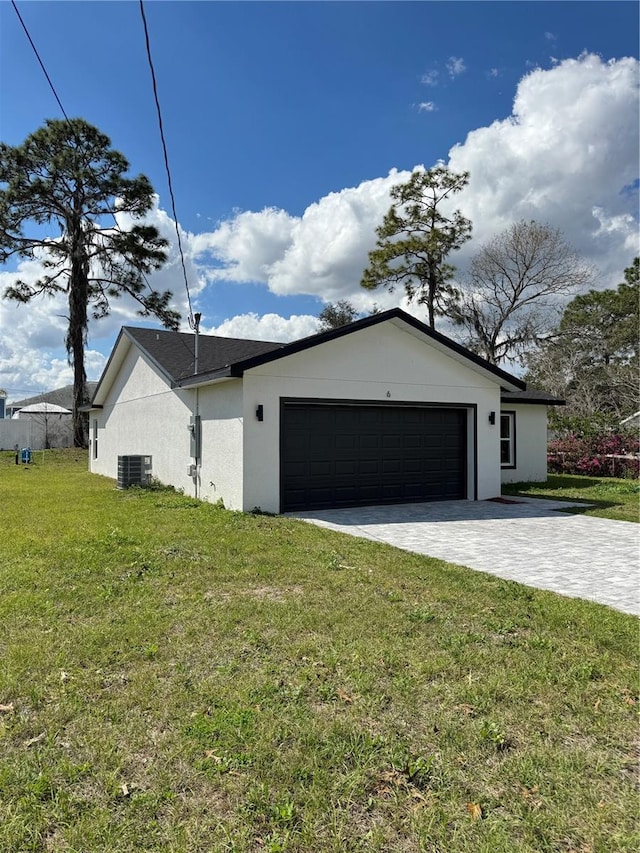 view of home's exterior featuring central air condition unit, a garage, a yard, decorative driveway, and stucco siding