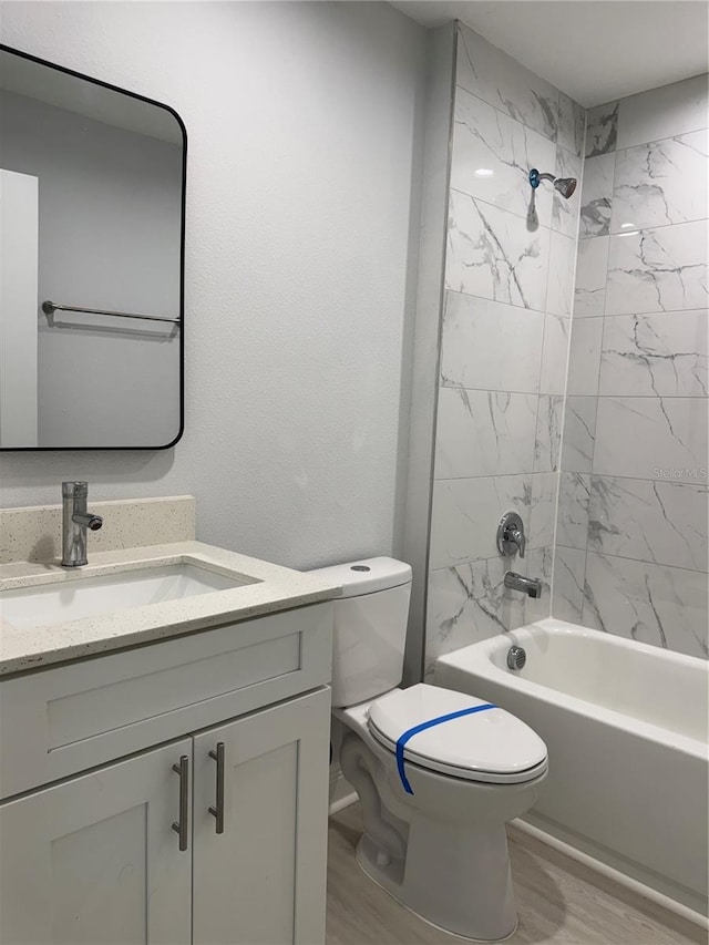 bathroom featuring wood finished floors, shower / washtub combination, vanity, and toilet