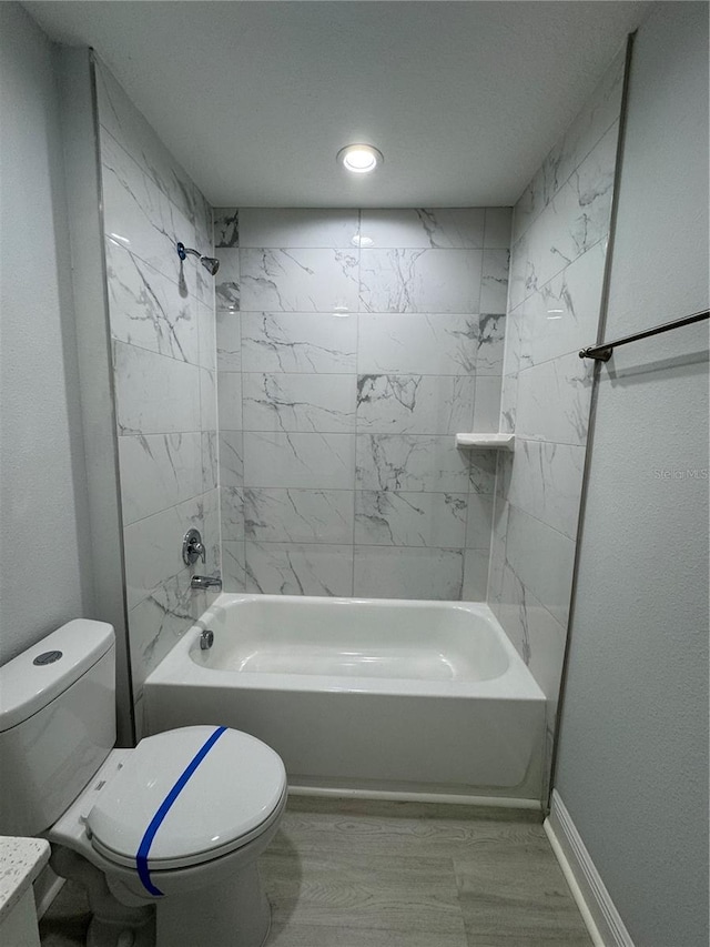 bathroom featuring baseboards, shower / bath combination, and toilet