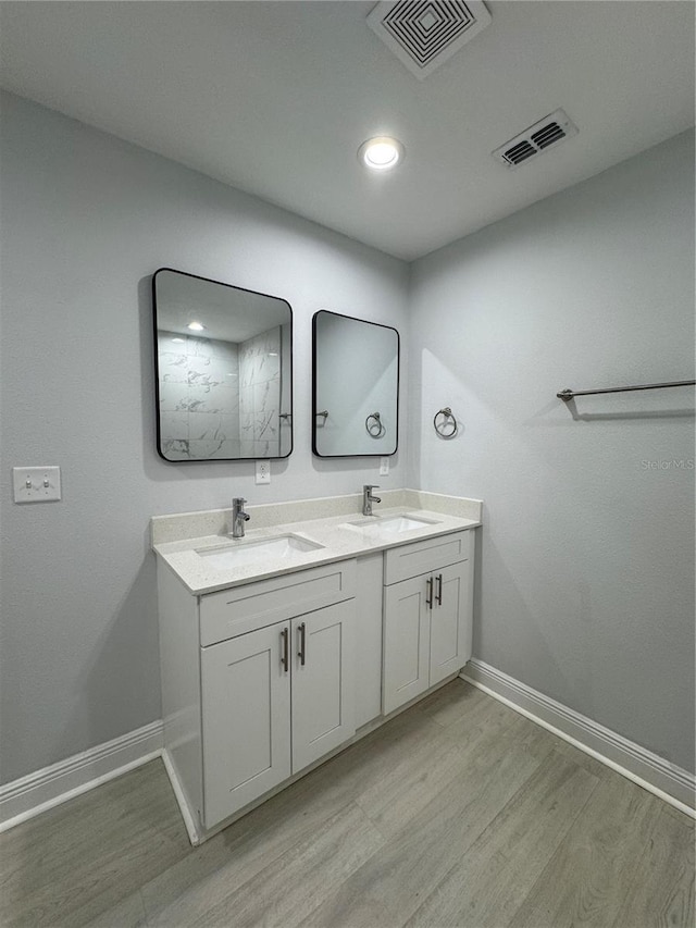 full bathroom with wood finished floors, a sink, and visible vents