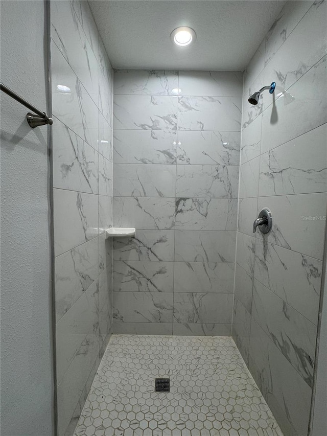 bathroom with a stall shower and a textured ceiling