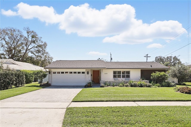 single story home featuring a garage, a front lawn, and decorative driveway