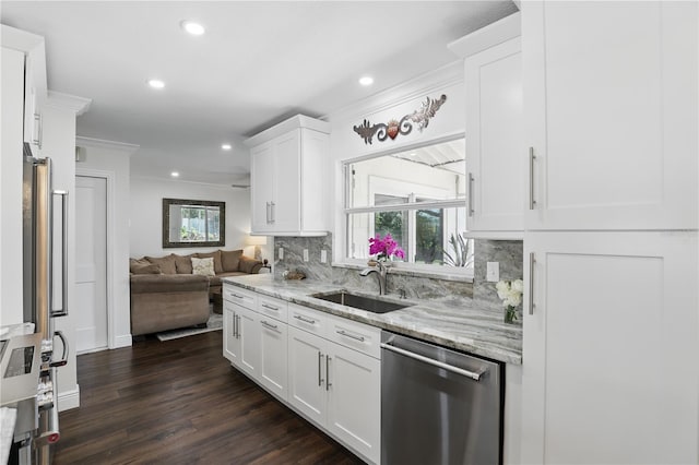 kitchen with plenty of natural light, backsplash, open floor plan, stainless steel dishwasher, and a sink