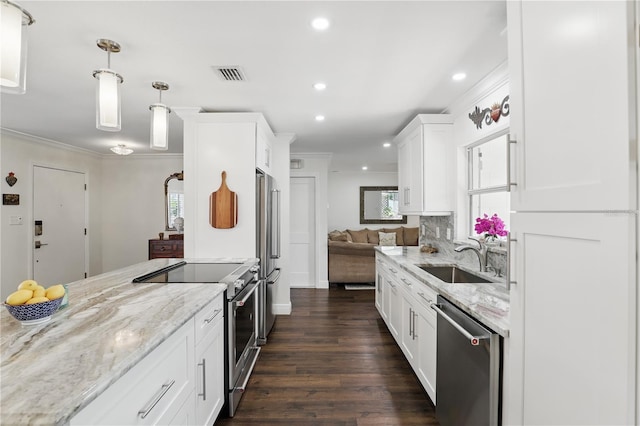 kitchen featuring high quality appliances, visible vents, light stone counters, and a sink