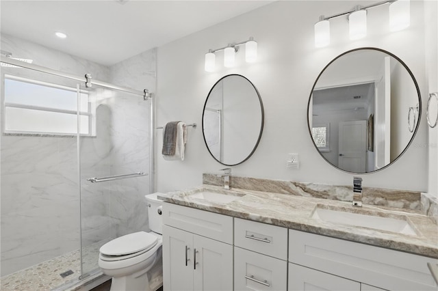 bathroom with toilet, a sink, and a marble finish shower