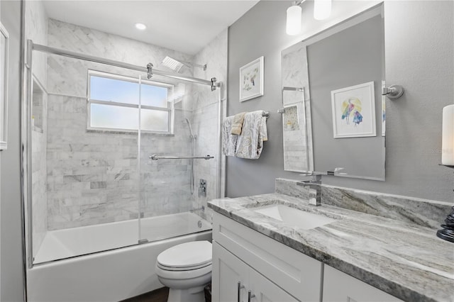 full bath featuring toilet, enclosed tub / shower combo, and vanity