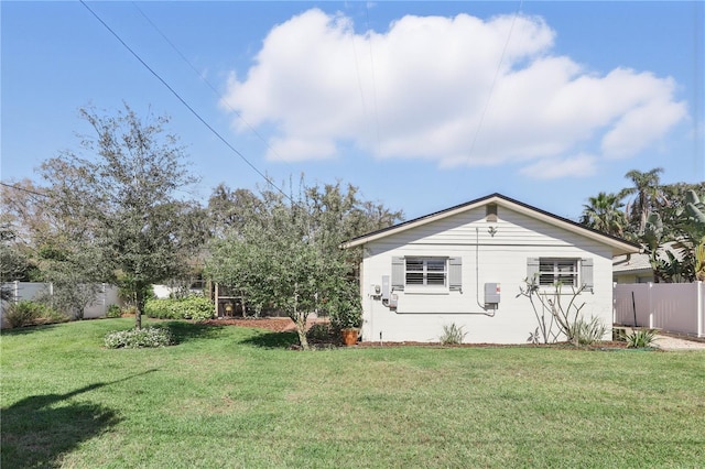 exterior space with fence and a lawn
