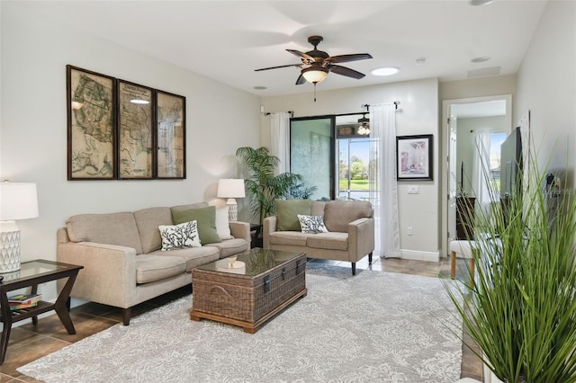 living room featuring a ceiling fan, tile patterned flooring, and baseboards