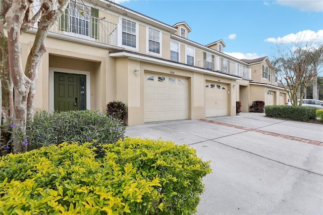 view of front of property with a garage, concrete driveway, and stucco siding