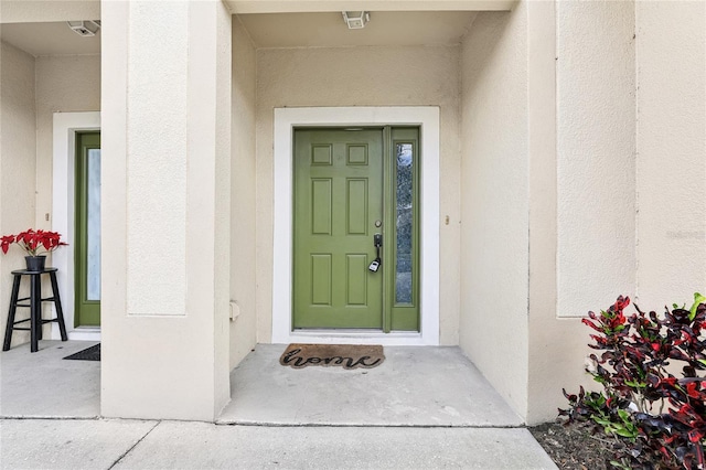 view of exterior entry featuring stucco siding