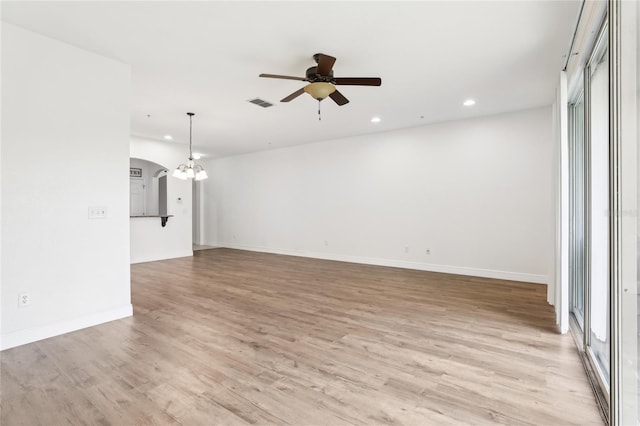 spare room with recessed lighting, visible vents, light wood finished floors, and ceiling fan with notable chandelier