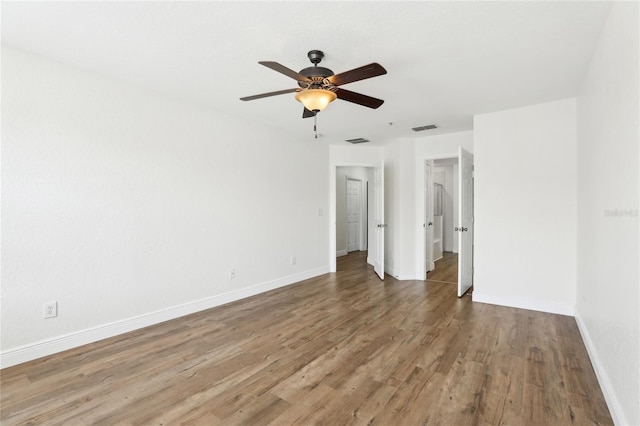 unfurnished bedroom featuring a ceiling fan, wood finished floors, visible vents, and baseboards