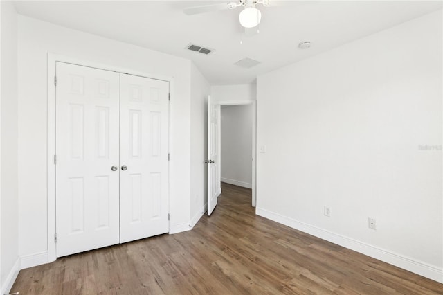 unfurnished bedroom featuring a closet, visible vents, ceiling fan, wood finished floors, and baseboards