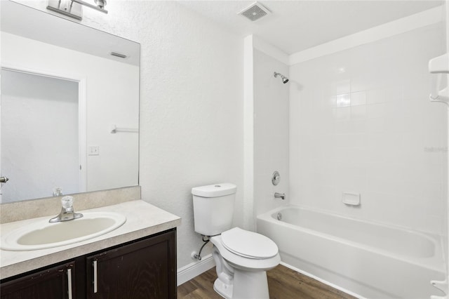 bathroom with bathtub / shower combination, visible vents, toilet, vanity, and wood finished floors