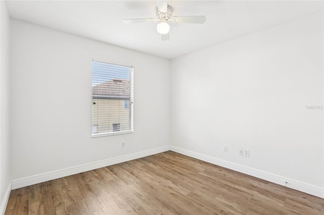 unfurnished room with a ceiling fan, baseboards, and wood finished floors