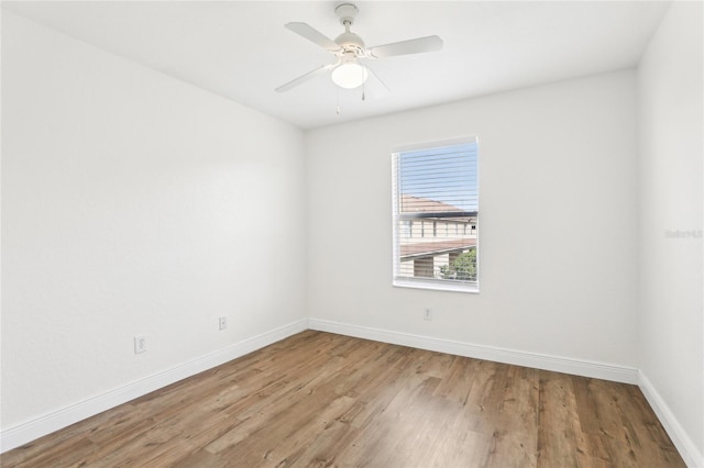 empty room with ceiling fan, baseboards, and wood finished floors