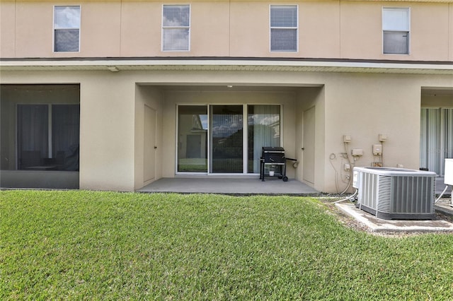 back of house with a lawn, a patio area, cooling unit, and stucco siding