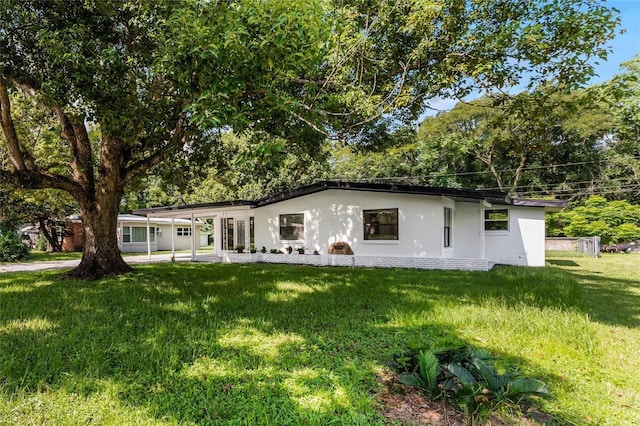 view of front facade with an attached carport and a front lawn