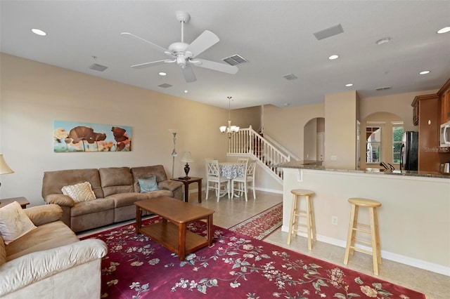 living room with arched walkways, recessed lighting, visible vents, baseboards, and ceiling fan with notable chandelier