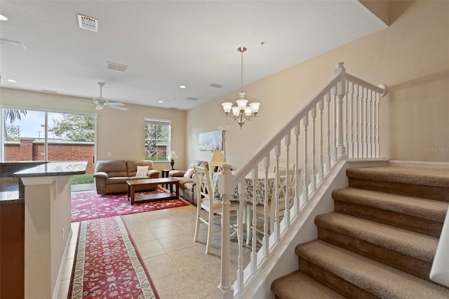 stairs with tile patterned flooring, ceiling fan with notable chandelier, visible vents, and recessed lighting