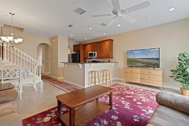 living room with arched walkways, visible vents, baseboards, and recessed lighting