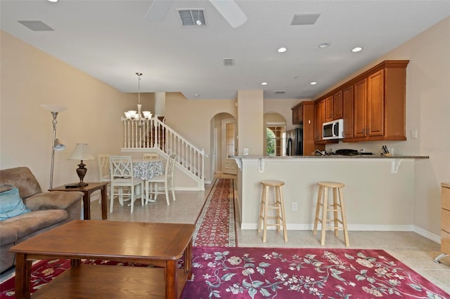 living room featuring baseboards, visible vents, arched walkways, and recessed lighting