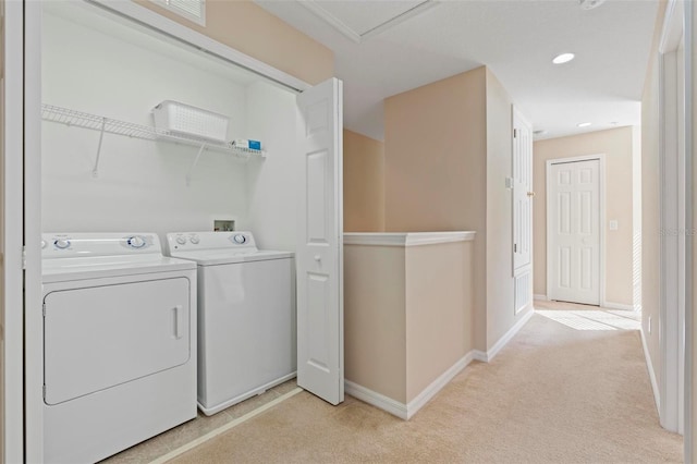 clothes washing area featuring light carpet, laundry area, baseboards, and washer and dryer