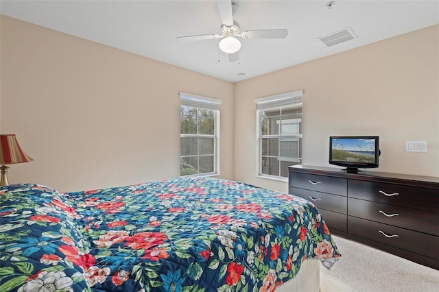 carpeted bedroom featuring visible vents and a ceiling fan