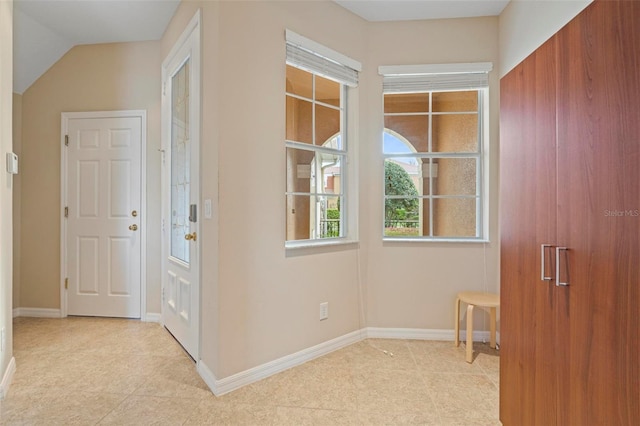 hall featuring tile patterned flooring and baseboards