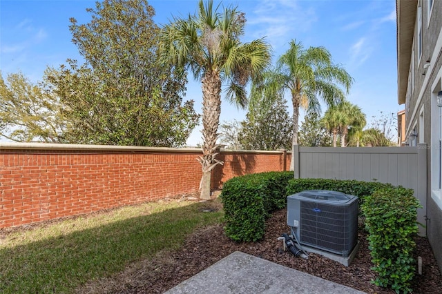 view of yard featuring fence and central AC