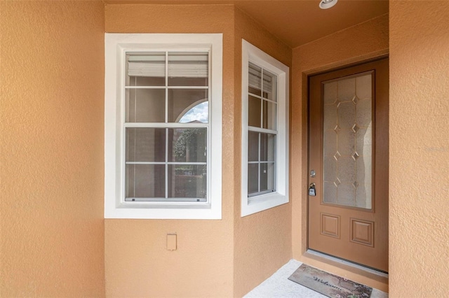 view of exterior entry featuring stucco siding