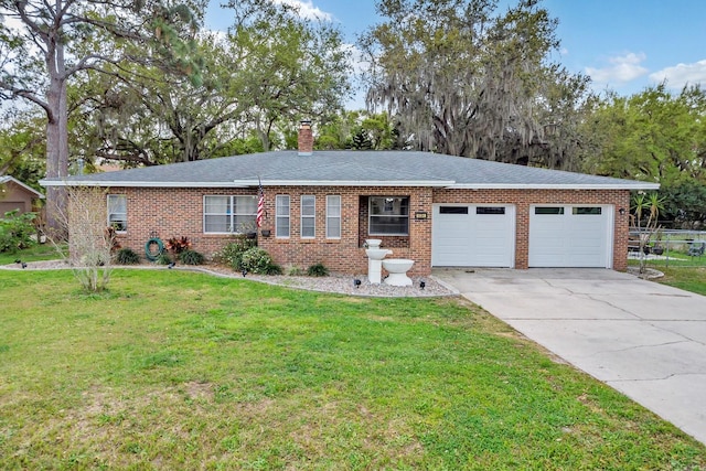 single story home featuring driveway, an attached garage, a chimney, a front lawn, and brick siding