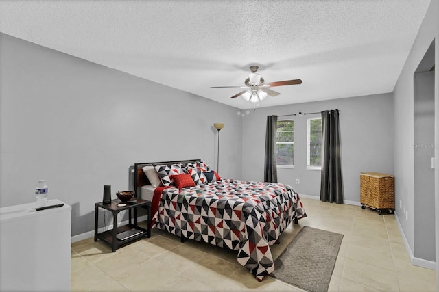 bedroom with light tile patterned floors, a textured ceiling, baseboards, and a ceiling fan