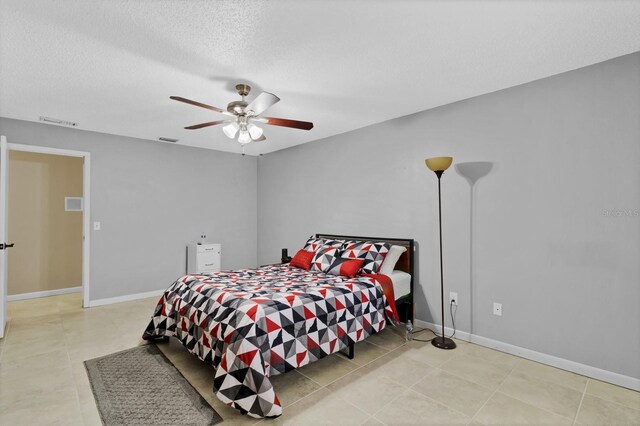 bedroom with visible vents, baseboards, a textured ceiling, and a ceiling fan