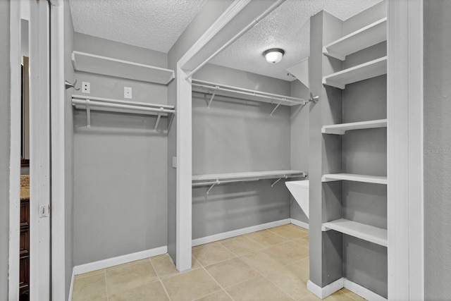 walk in closet with tile patterned floors