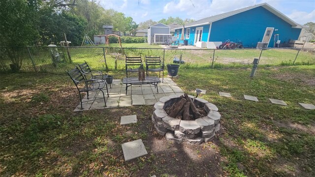 view of yard featuring an outdoor fire pit, a patio, and fence