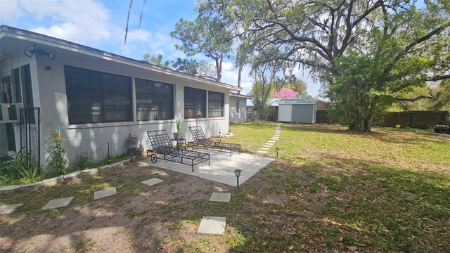 view of yard with a patio, a storage shed, an outdoor structure, and fence