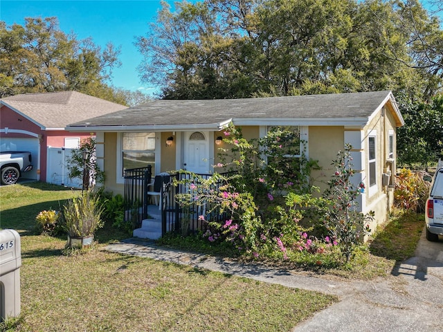 single story home featuring stucco siding and a front yard