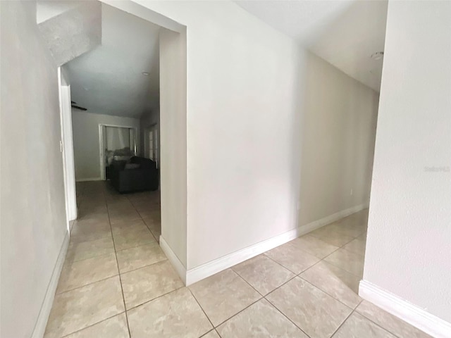 hallway with light tile patterned floors and baseboards