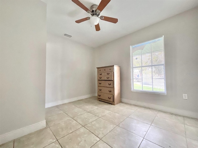 spare room with light tile patterned floors, visible vents, baseboards, and a ceiling fan